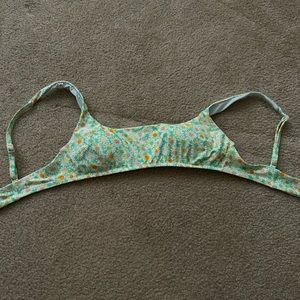 This is an aerie swim top in size small, green with daisy as the pattern
